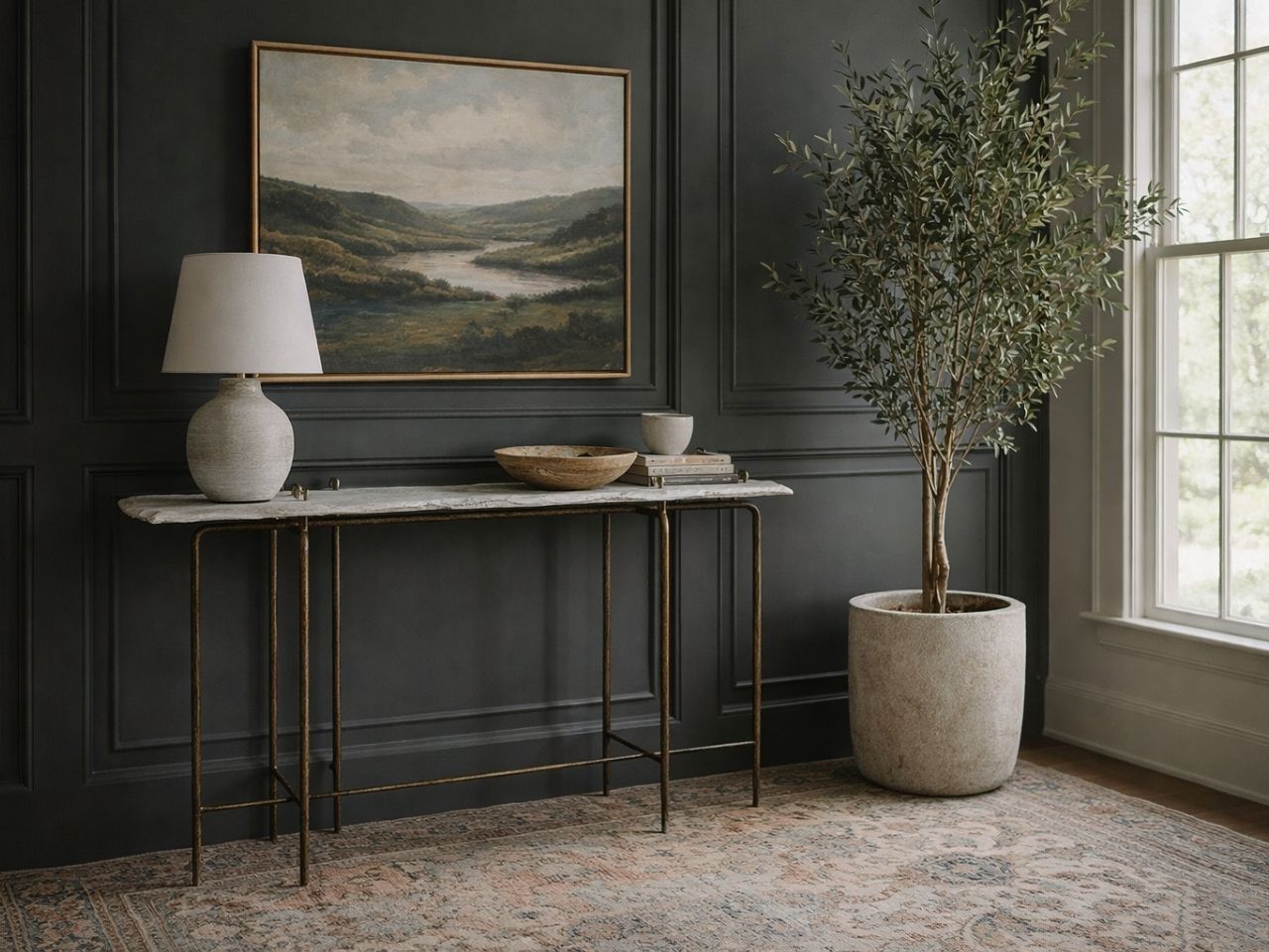 A slim console table with a white marble top and a thin antique gold-finished metal frame. 
