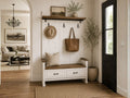 White hall bench with storage and coat hooks in a modern farmhouse entryway.