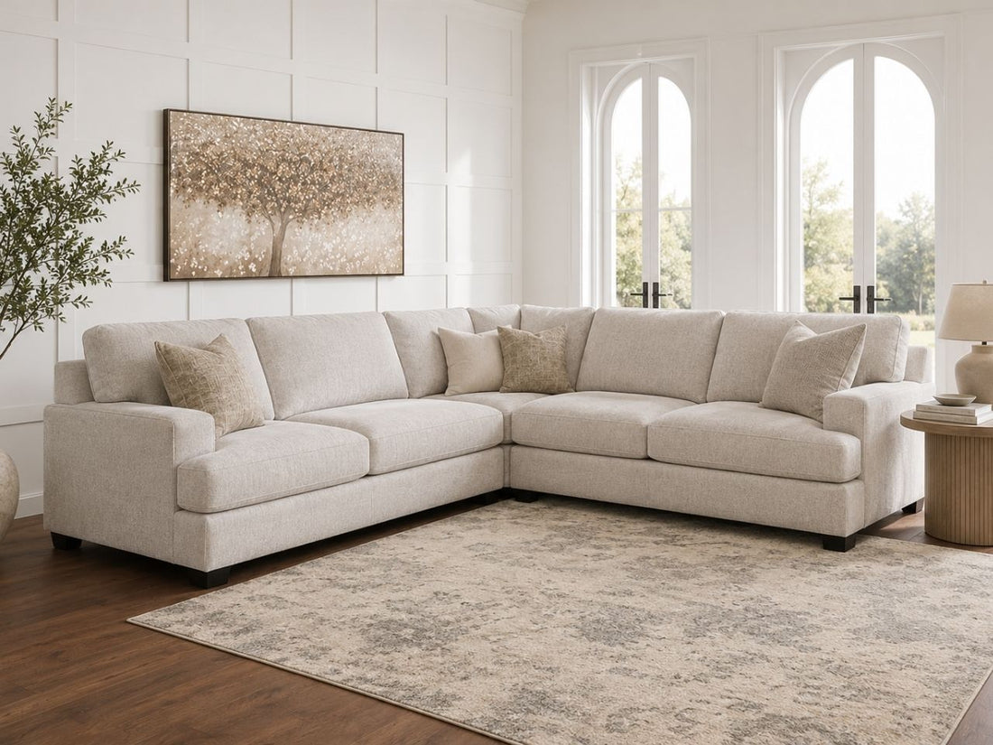 Light beige fabric sectional in a bright elegant living room.