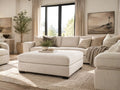 Cream upholstered ottoman in a luxurious modern living room with neutral décor, featuring stylish contemporary furniture in Calgary.