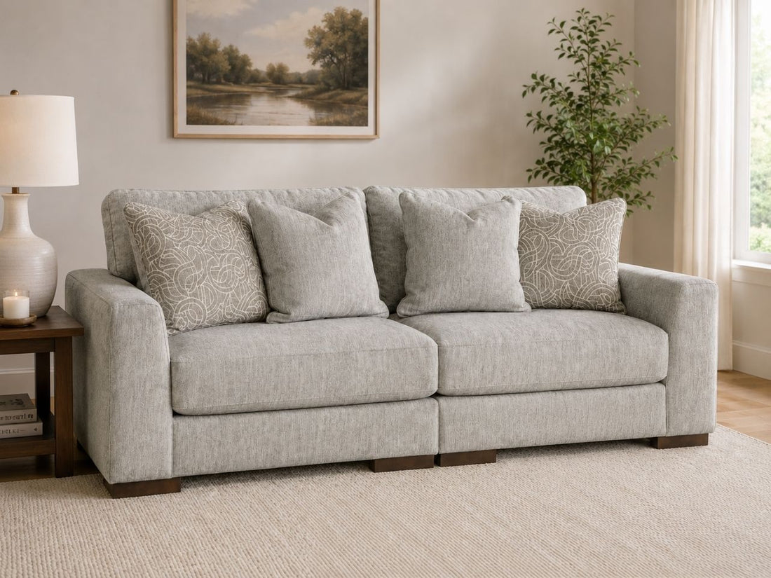 Light gray 2-piece loveseat sectional sofa with matching accent pillows in a cozy modern living room.