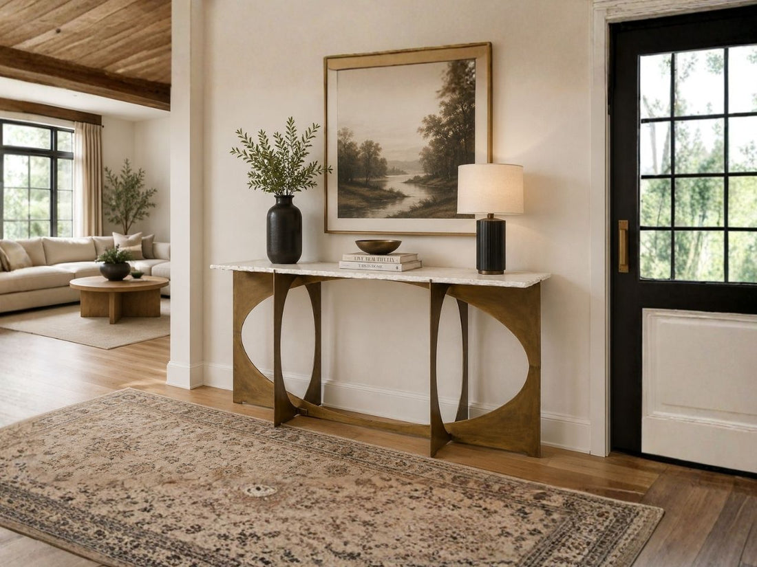 Marble-top console table styled in a bright modern entryway with neutral décor.