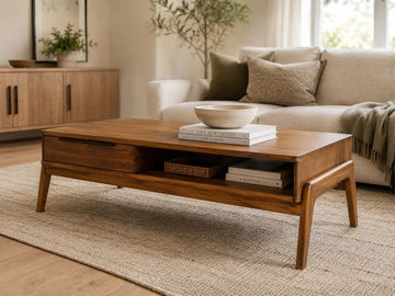 Mid-century modern wood coffee table with drawer storage in a cozy living room.