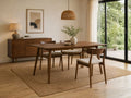Wood dining table with four upholstered chairs in a modern dining room.