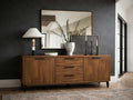 A medium-toned wooden sideboard with two doors and three central drawers, featuring slim black handles and legs.