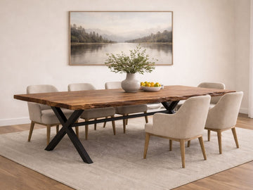 Live edge solid wood dining table with black metal X legs and upholstered chairs in a neutral dining room.