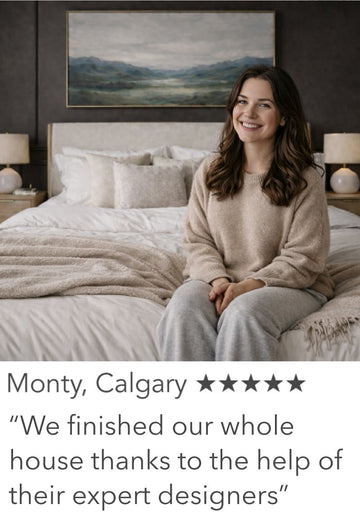Woman sitting on a bed in a stylish bedroom with a painting on the wall.