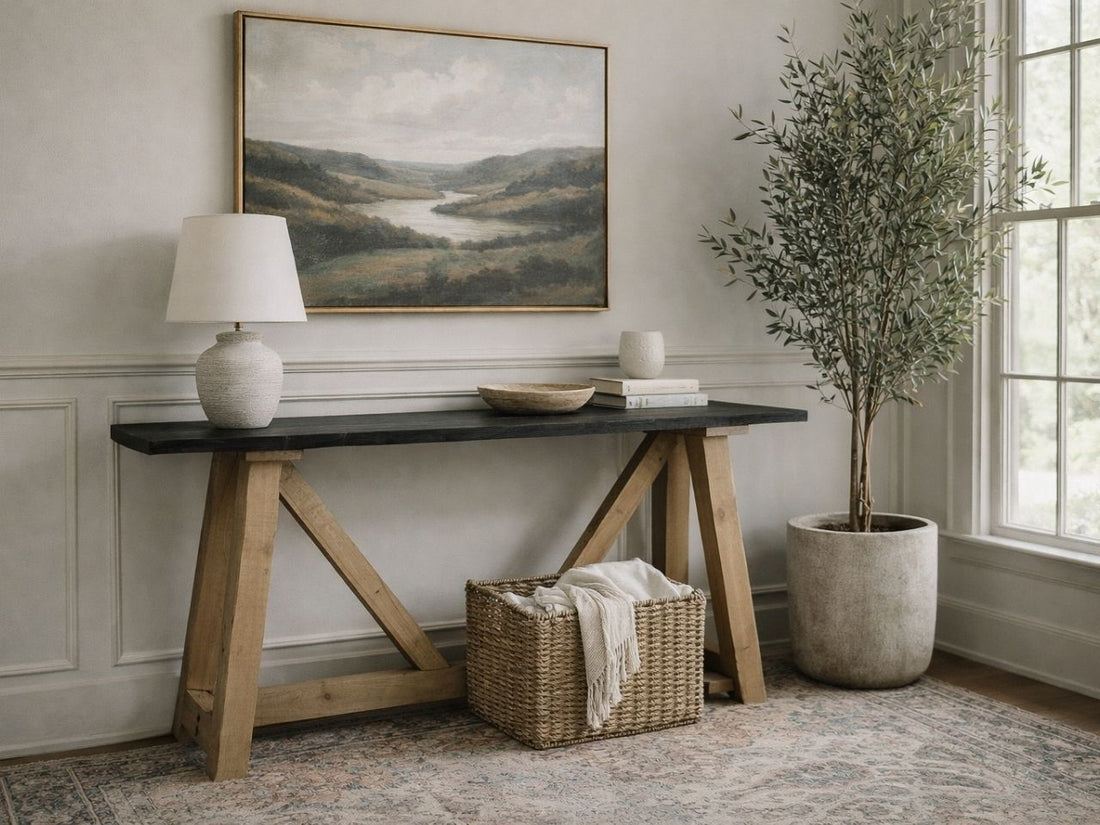 The Rialto Console Table features a high-contrast, mixed-material design. It has a long, slim rectangular tabletop with a dark charcoal or black wood finish.