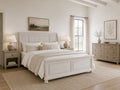 White sleigh bed with a storage footboard in a bright farmhouse-style bedroom.