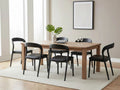 Black dining chairs around a wood dining table in a modern dining room.
