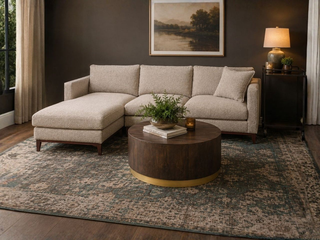 Round wood coffee table with a brass base in a cozy living room.
