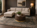 Round wood coffee table with a brass base in a cozy living room.