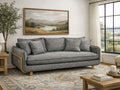 A gray upholstered sofa with wooden accents in a cozy, modern living room.