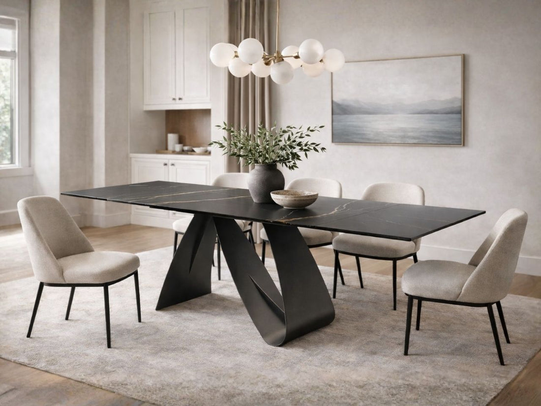Black extension dining table with sculptural base and upholstered chairs in a modern dining room.