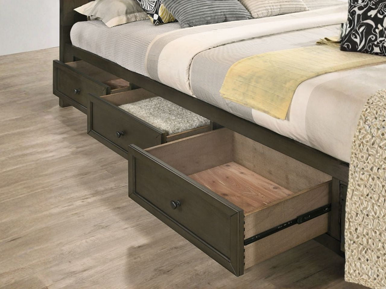 A wooden bed frame with built-in storage drawers pulled open underneath.