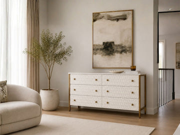 White textured sideboard with gold accents styled in a bright modern living room.