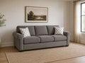 Gray fabric sofa sleeper with patterned accent pillows in a cozy modern living room.