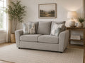Light gray chenille loveseat with soft accent pillows in a cozy and modern living room.