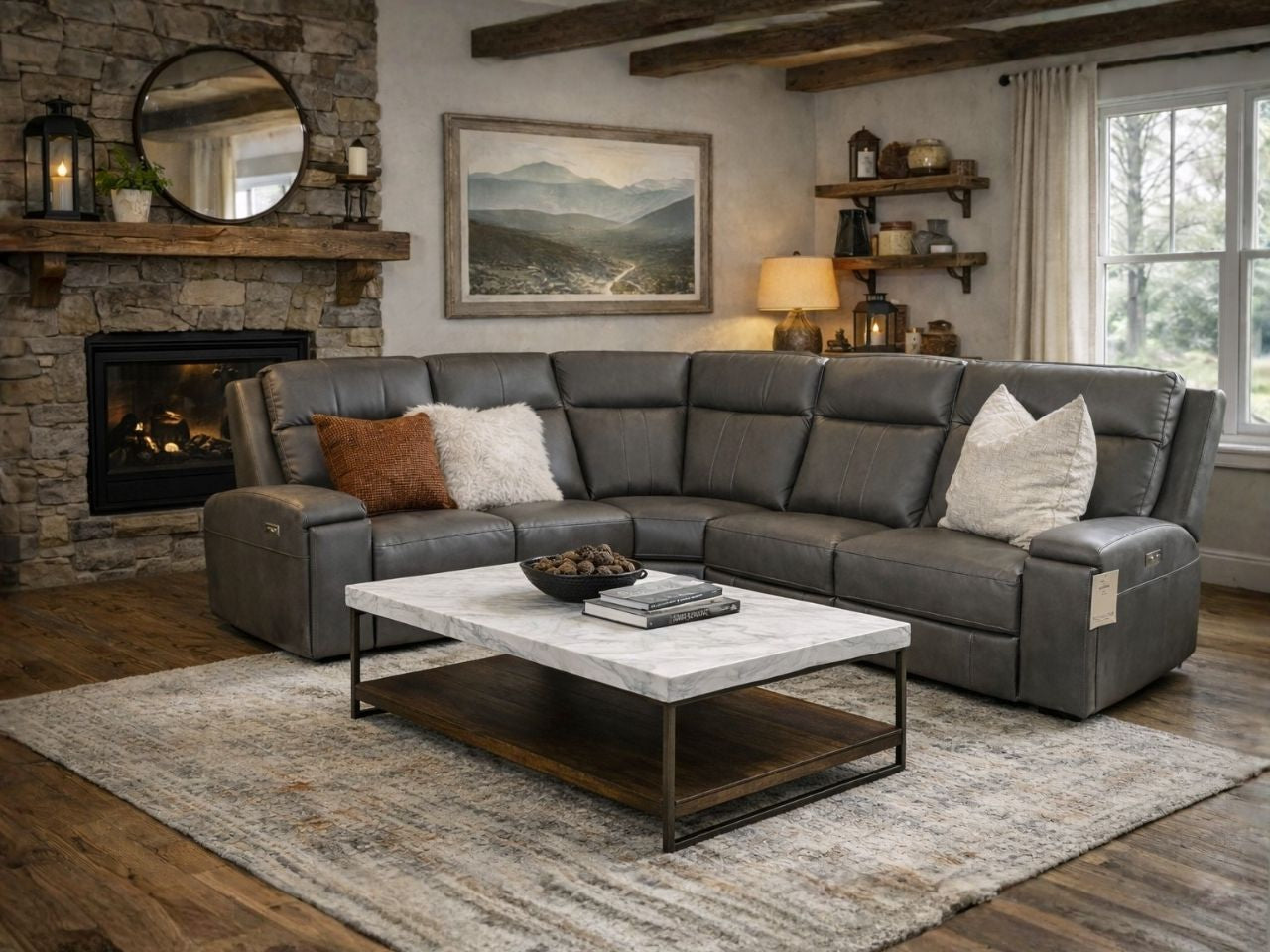 A gray leather sectional sofa styled in a warm, rustic living room with a stone fireplace.