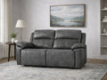Gray leather reclining loveseat with padded arms in a living room.