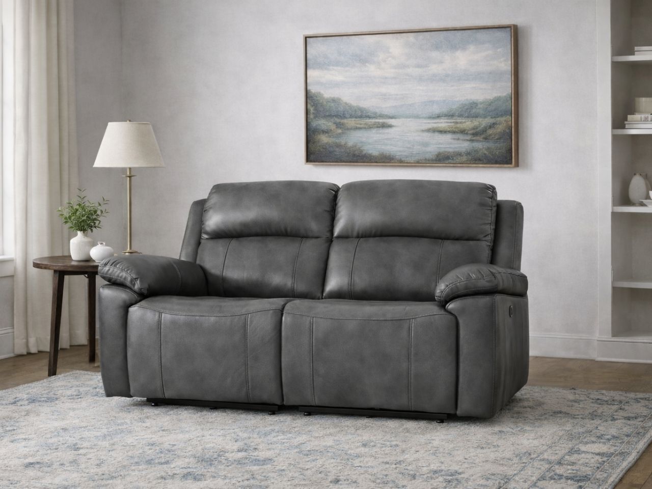 Gray leather reclining loveseat with padded arms in a living room.