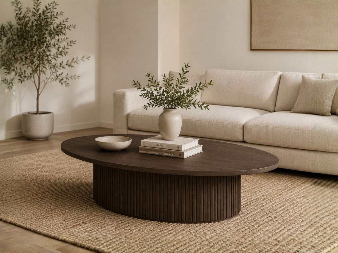 Oval wood coffee table with a fluted base in a modern living room.