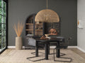 Woven rattan dome pendant light hanging above a dining table in a styled interior setting.