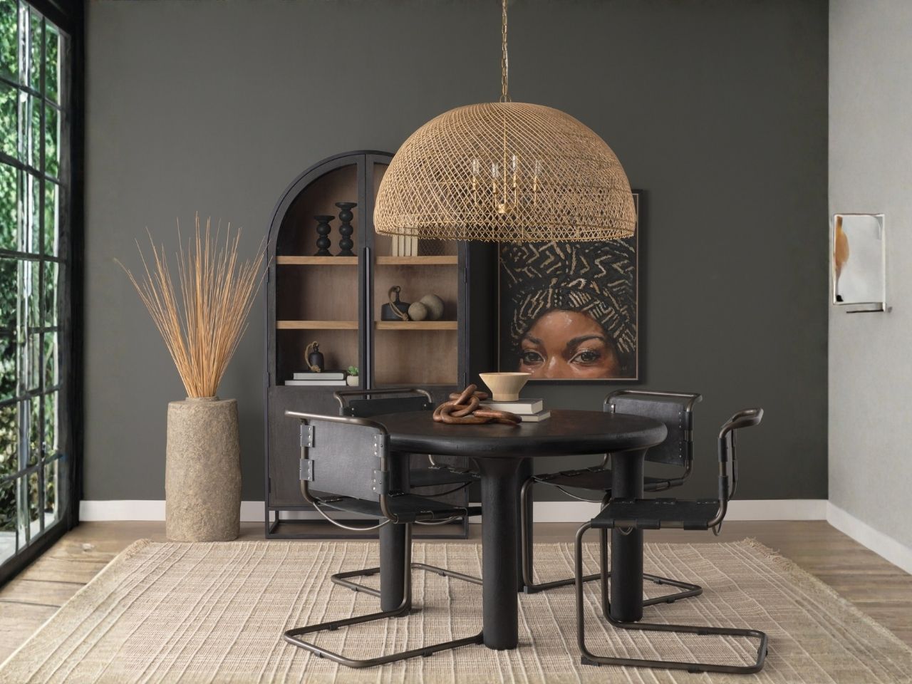 Woven rattan dome pendant light hanging above a dining table in a styled interior setting.