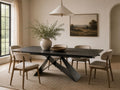 Slate grey dining table with six upholstered chairs.
