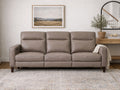 A taupe leather sofa styled in a warm, modern living space.