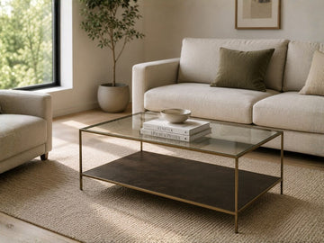 Glass coffee table with a metal frame and lower shelf in a modern living room.