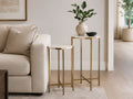 Marble top nesting side tables with gold metal frames beside a cream sofa.