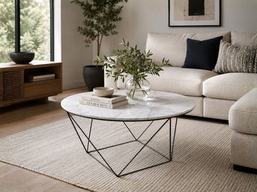 Round white marble coffee table with a black metal base in a modern living room.