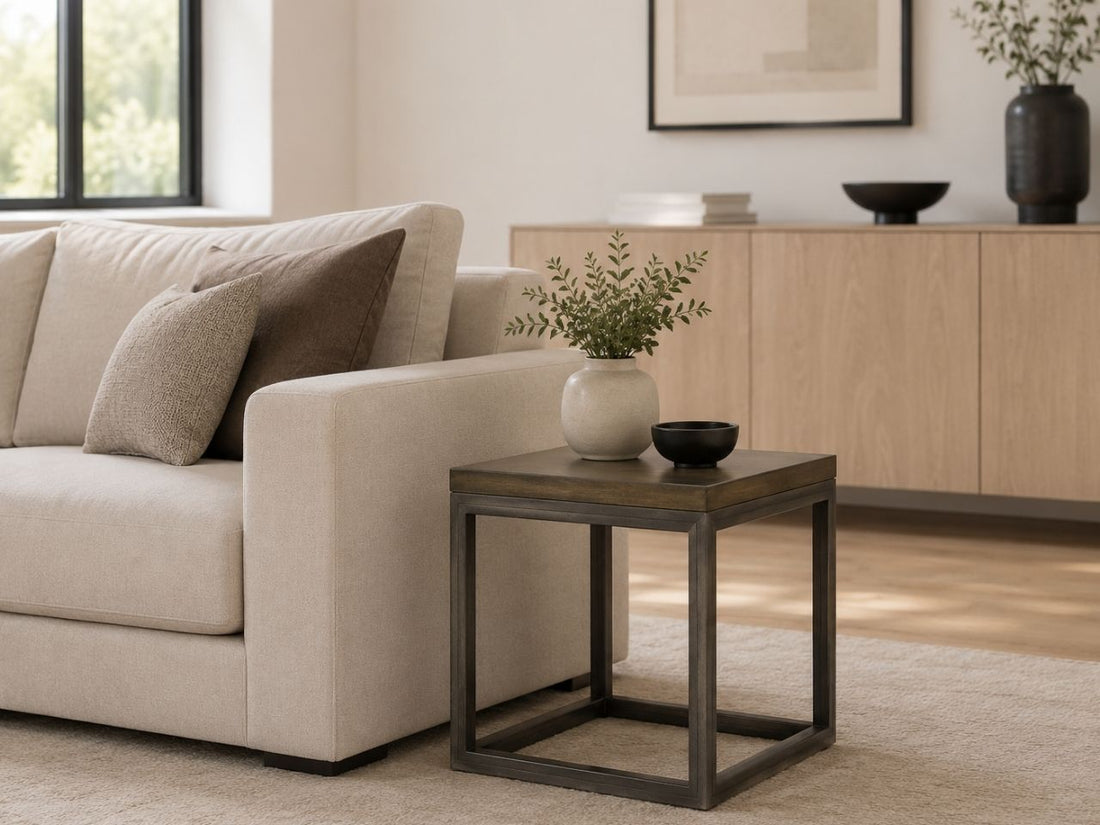 Modern square solid wood side table with an open cube base, styled beside a cream sofa in a minimalist contemporary living room.