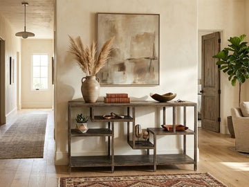 Rustic wood console table with open shelving styled in a modern hallway.