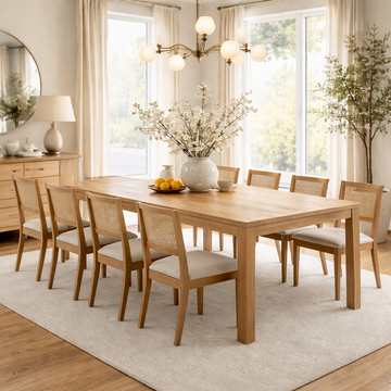 Dining room with extendable wooden table and chairs, large windows, and decorative elements.